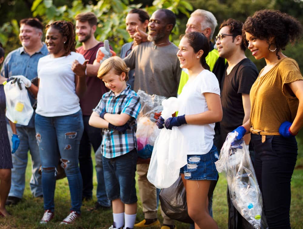 Group of smiling people supporting the community by picking up trash